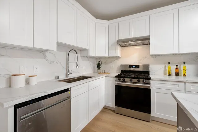 a kitchen with granite countertop white cabinets and white appliances
