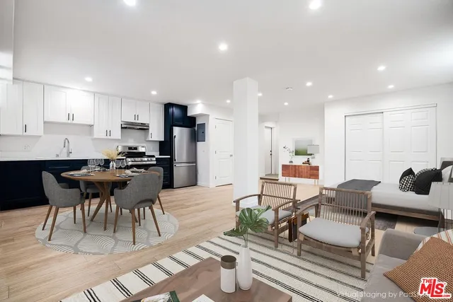 a dining room with stainless steel appliances kitchen island granite countertop a dining table chairs and view kitchen