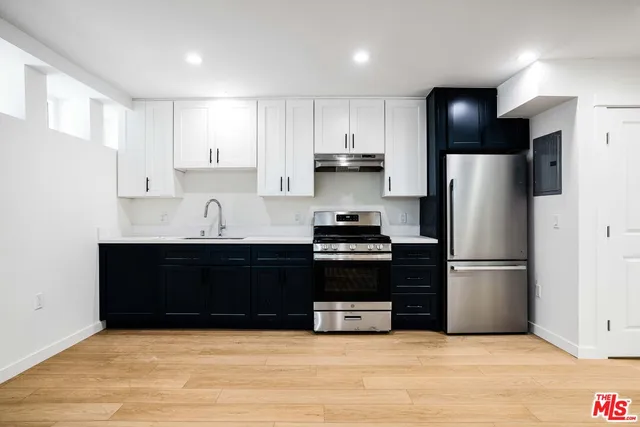a kitchen with stainless steel appliances a refrigerator sink and cabinets