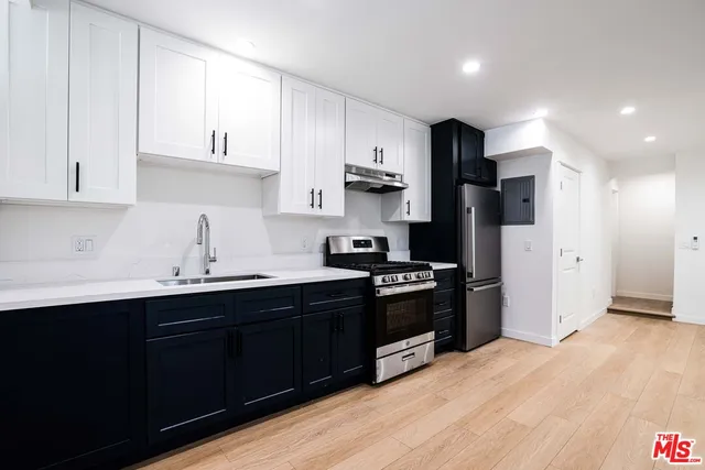 a kitchen with stainless steel appliances granite countertop a sink stove and refrigerator