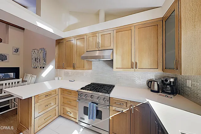 a kitchen with stainless steel appliances white cabinets and a stove top oven