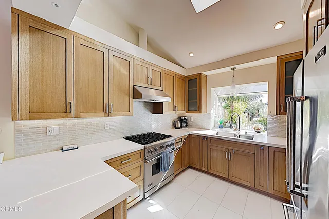a kitchen that has a sink a stove and a refrigerator