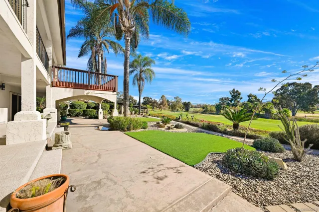 a view of a yard with plants and a patio