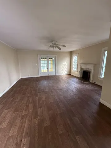 an empty room with wooden floor and fireplace