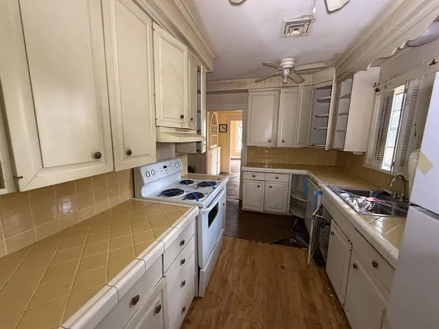 a kitchen with stainless steel appliances a sink stove and cabinets