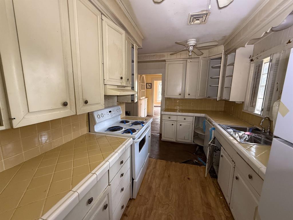 100 Smith Street Naples, TX 75568 - Photo 9 of 30 a kitchen with stainless steel appliances a sink stove and cabinets