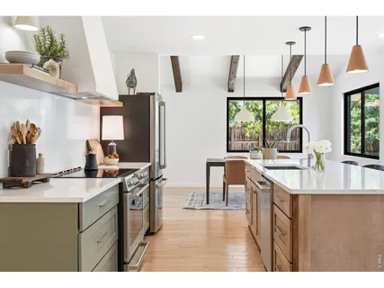 a kitchen with stainless steel appliances granite countertop a sink a stove and a refrigerator