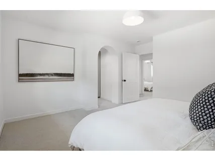 a bedroom with a bed and a painting on the wall