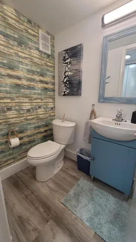 a bathroom with a toilet a sink and mirror