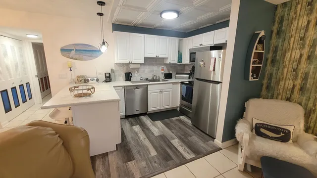 a kitchen with stainless steel appliances a refrigerator a sink a stove a microwave and island