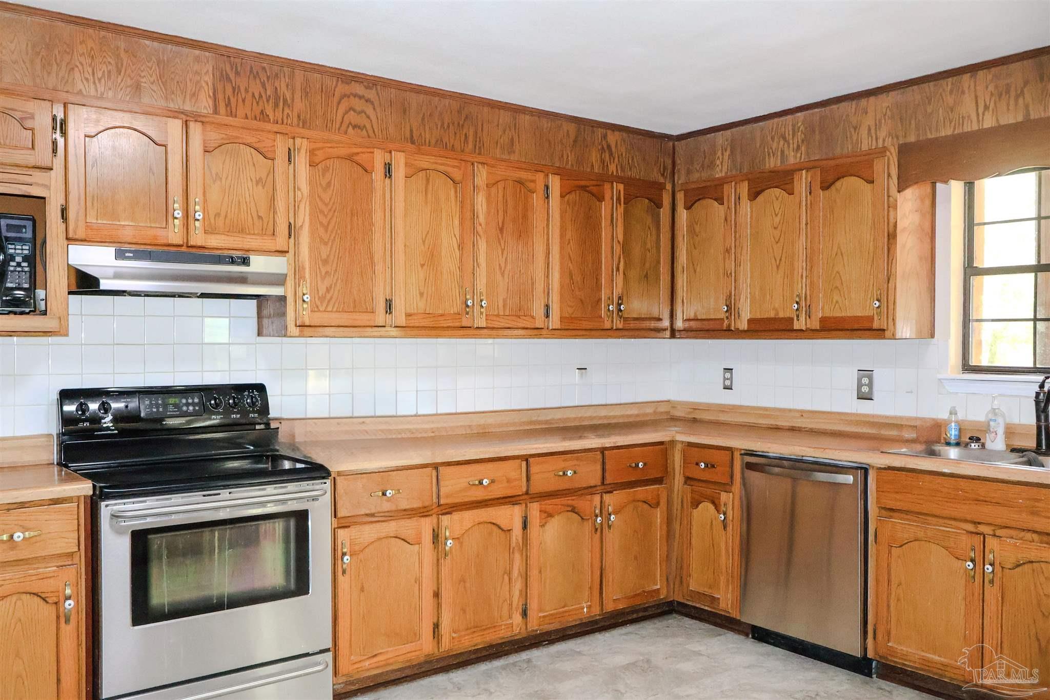111 Cotton Creek Road McDavid, FL 32568 - Photo 19 of 30 a kitchen with cabinets appliances a sink and a counter top