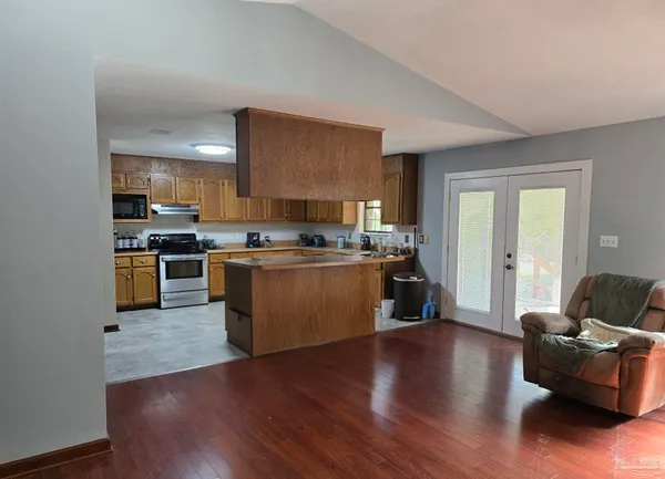 a kitchen with stainless steel appliances wooden floors and wooden cabinets