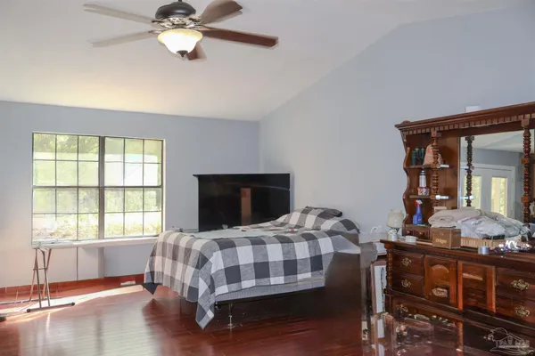 a bedroom with a bed and wooden floor