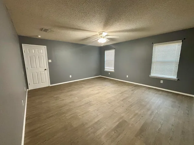 an empty room with an empty space and windows