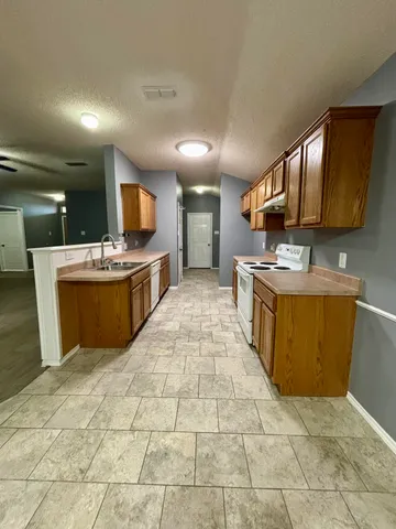 a kitchen with stainless steel appliances granite countertop a sink and a stove