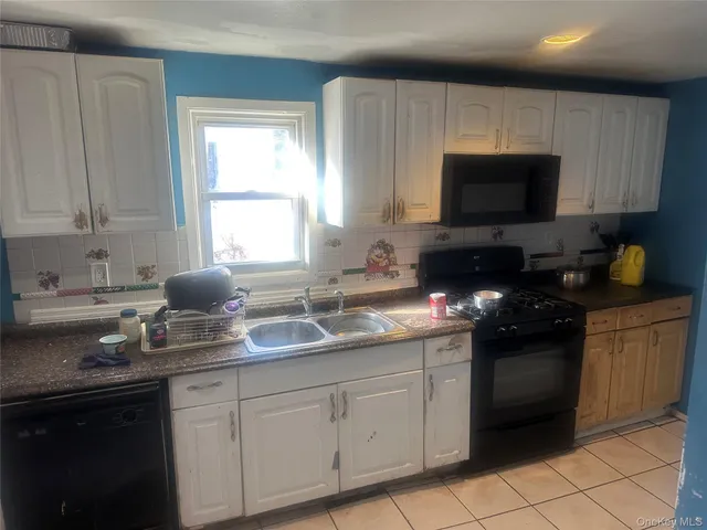 a kitchen with granite countertop a sink dishwasher stove and cabinets