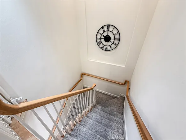 a view of staircase with wooden floor and white walls