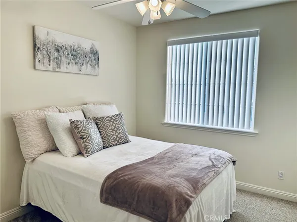 a bedroom with bed and a painting on the wall