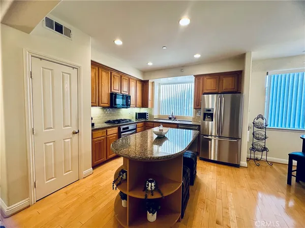 a kitchen with stainless steel appliances granite countertop a sink stove and refrigerator