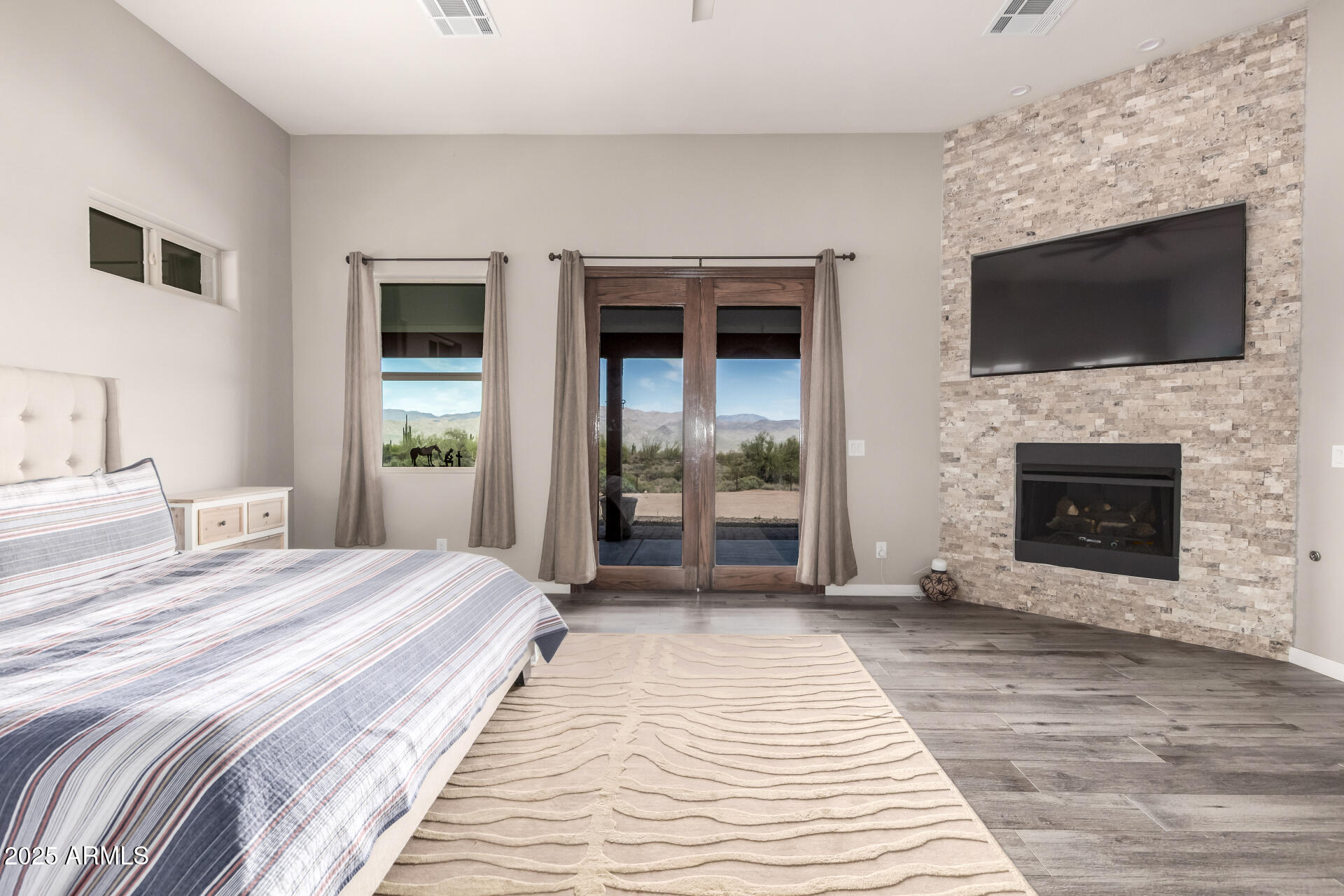 17024 East Lone Mountain Road Rio Verde, AZ 85263 - Photo 21 of 42 a spacious bedroom with a bed and a flat screen tv