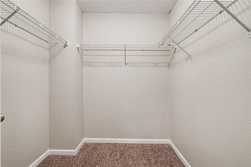 10941 Wheeler Trace Hampton, GA 30228 - Photo 17 of 21 a view of walk in closet with empty racks