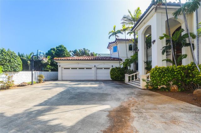 a view of a house with a yard and potted plants