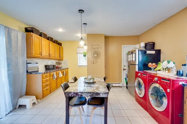 a kitchen with stainless steel appliances granite countertop a sink a stove a refrigerator a microwave oven with a dining table and chairs