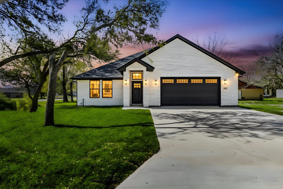 a front view of a house with a garden and yard