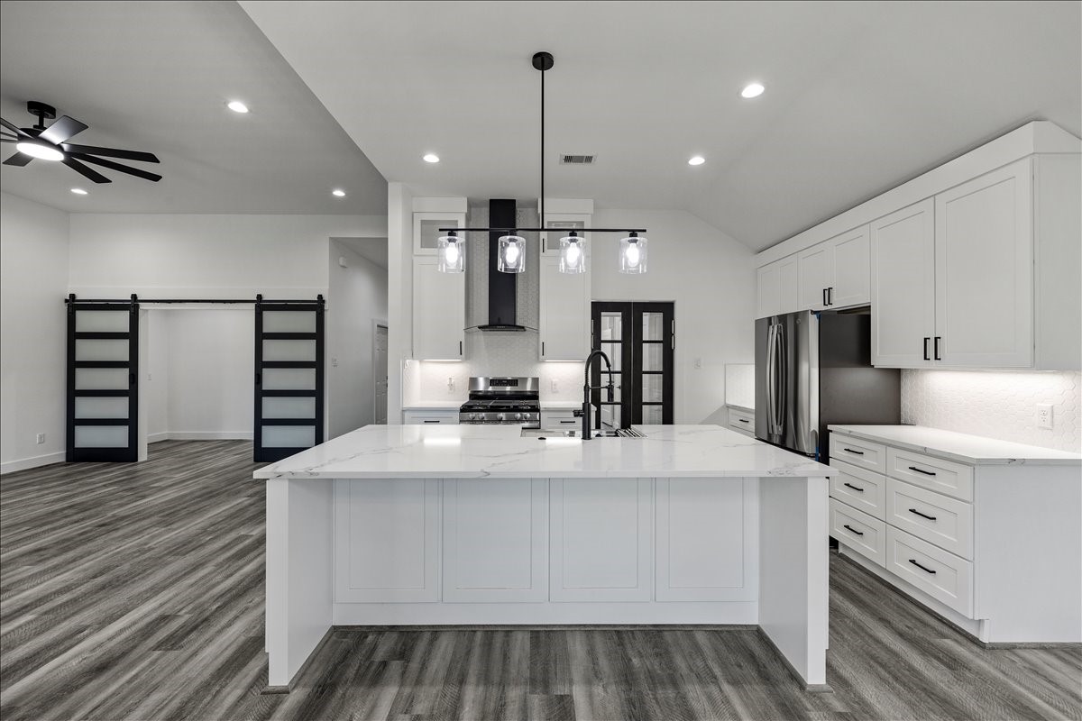14103 3rd Street Santa Fe, TX 77517 - Photo 13 of 46 a large kitchen with stainless steel appliances kitchen island granite countertop a stove and a refrigerator