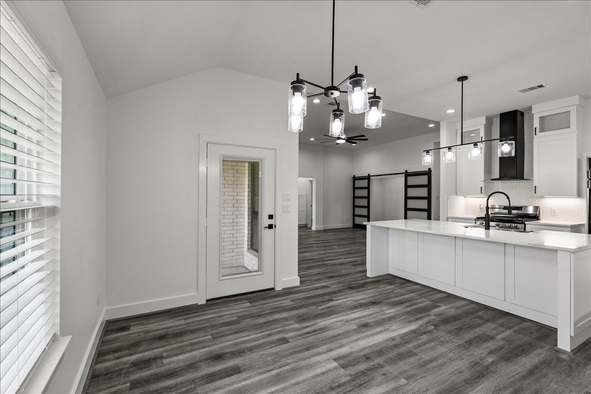 14103 3rd Street Santa Fe, TX 77517 - Photo 18 of 46 a view of a kitchen with stainless steel appliances granite countertop a refrigerator a sink dishwasher and a fireplace with wooden floor