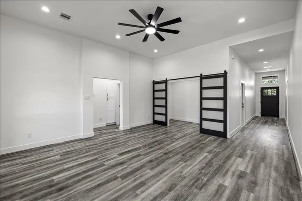 a view of a hallway with wooden floor and staircase
