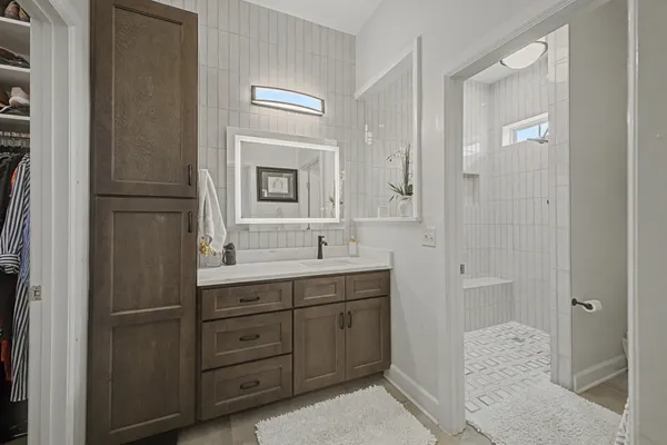a bathroom with a double vanity sink and mirror with shower
