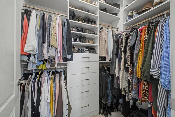 a view of walk in closet with clothes and shoes