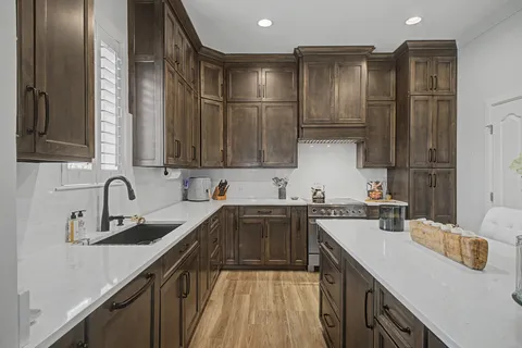 a kitchen with a sink a stove and cabinets