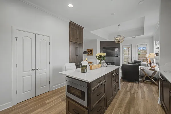 a view of kitchen island wooden floor and living room