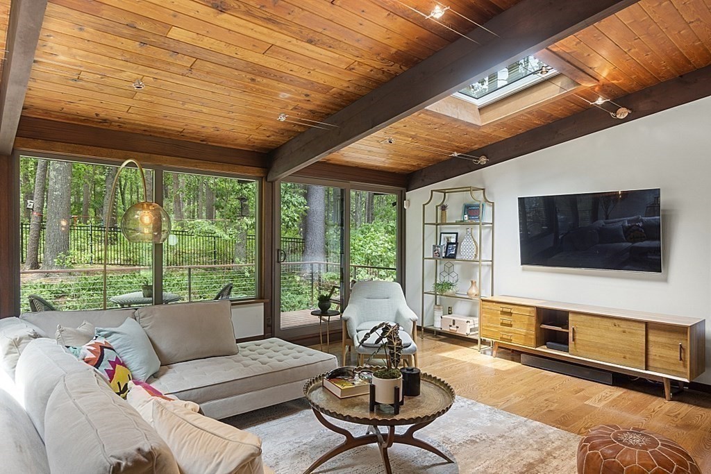 127 Commerford Road Concord, MA 01742 - Photo 11 of 33 a living room with furniture a flat screen tv and a floor to ceiling window