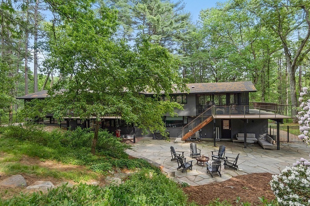 127 Commerford Road Concord, MA 01742 - Photo 30 of 33 a view of a patio with table and chairs under an umbrella with large trees