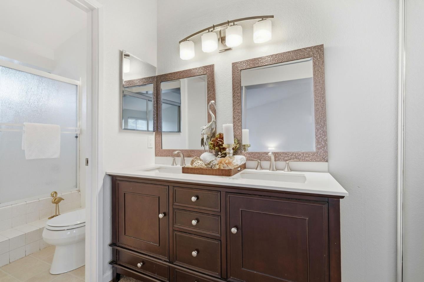 283 Perch Way Aptos, CA 95003 - Photo 29 of 37 a bathroom with a toilet a double vanity sink and a mirror
