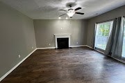 4557 Ivy Patch Drive Fortson, GA 31808 - Photo 4 of 27 an empty room with windows fireplace and fan
