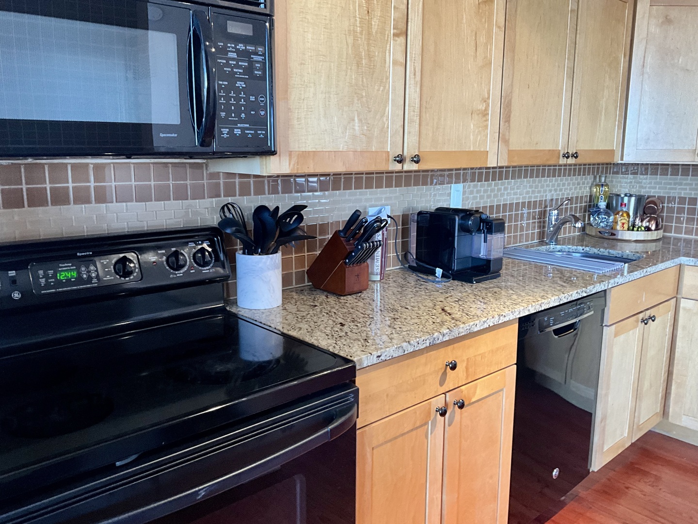 655 West Irving Park Road, Unit 2110 Chicago, IL 60613 - Photo 15 of 38 a kitchen with granite countertop a stove a sink and a microwave