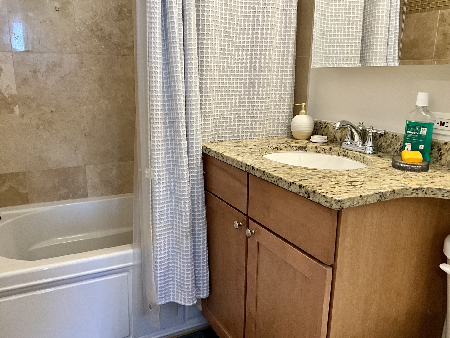 655 West Irving Park Road, Unit 2110 Chicago, IL 60613 - Photo 21 of 38 a bathroom with a granite countertop sink and a bathtub
