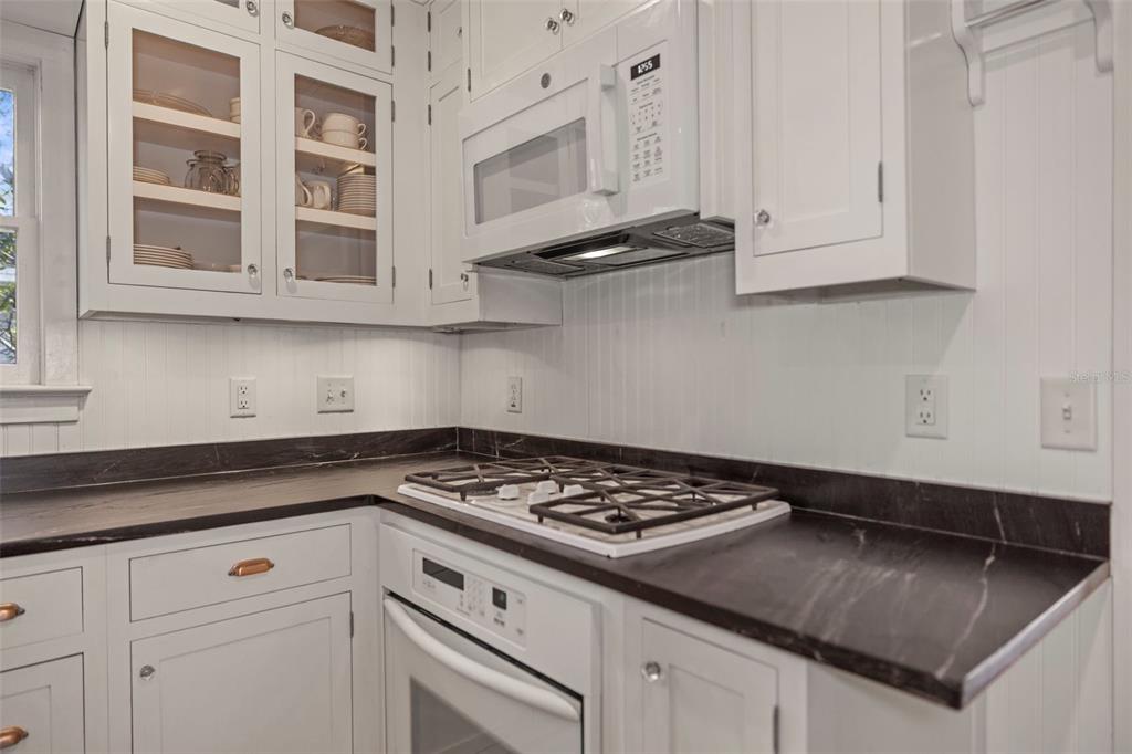637 Scotland Street Dunedin, FL 34698 - Photo 12 of 72 a kitchen with white cabinets and appliances