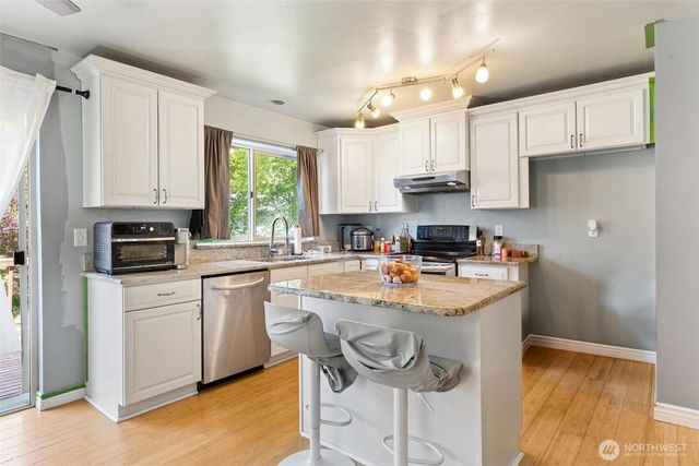 a kitchen with stainless steel appliances granite countertop a stove a sink and a refrigerator