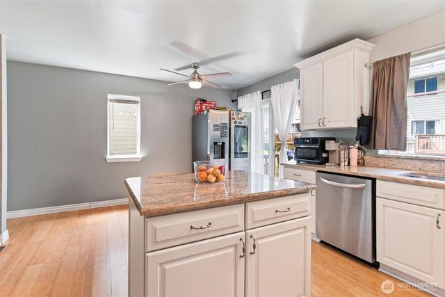 a kitchen with stainless steel appliances granite countertop a lot of counter space and wooden floors