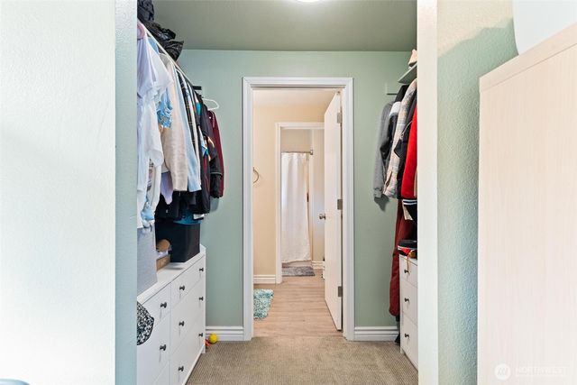 a view of walk in closet with clothes and shoes