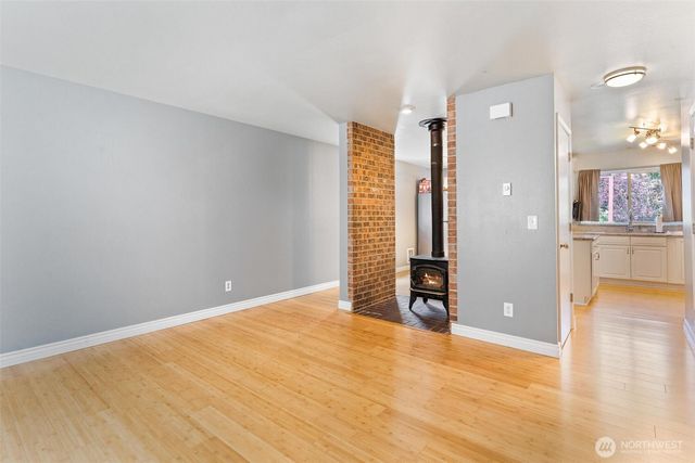 a view of an empty room with kitchen and a window