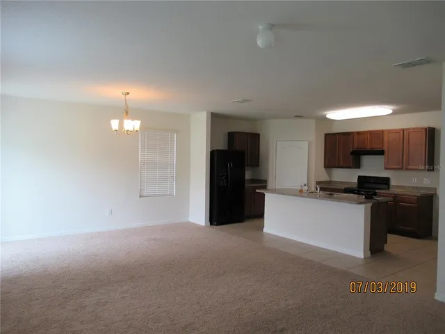 a kitchen with granite countertop a refrigerator and a stove