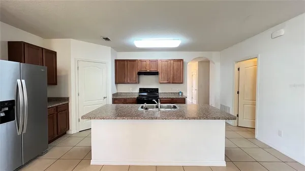 a kitchen with kitchen island a counter top space cabinets and stainless steel appliances