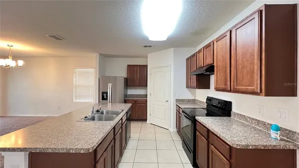 a kitchen with granite countertop kitchen island stainless steel appliances a sink stove and a granite counter top