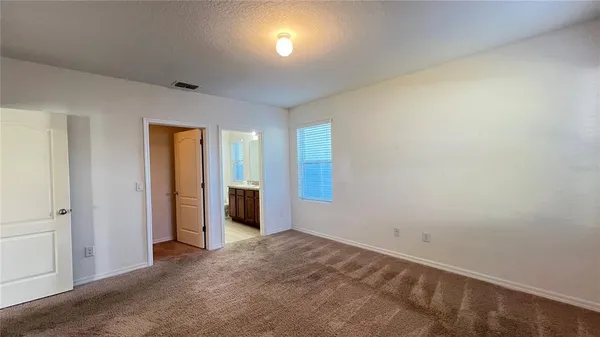 an empty room with closet and windows